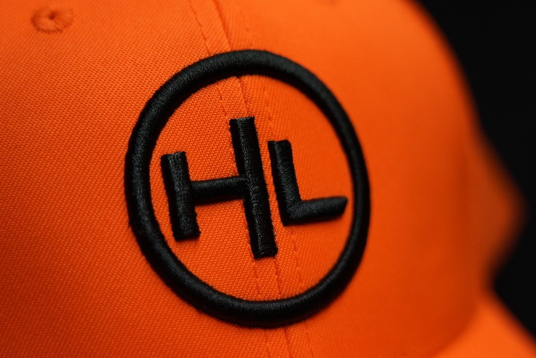 Close-up of the embroidered HL logo on the hunter orange hat