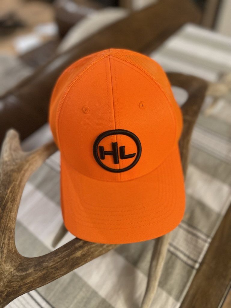 HuntLeague hunter orange hat resting on an antler