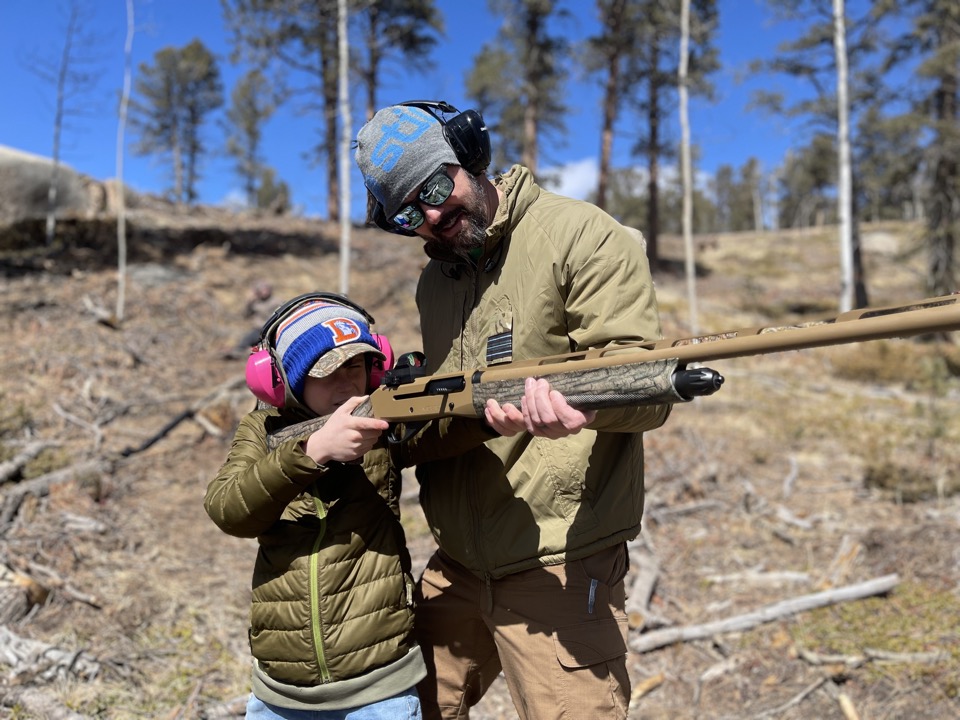 A hunter coaching a young shooter